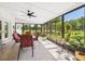 Enclosed patio offering a serene view of the backyard, furnished with a table and chairs at 14191 Se 25Th Ave, Summerfield, FL 34491