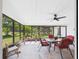 Covered sun room with table, chairs, ceiling fan and views of the backyard at 14191 Se 25Th Ave, Summerfield, FL 34491