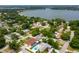 High aerial view of neighborhood with lush trees and the home's location shown near a lake at 1491 Avenue F Ne, Winter Haven, FL 33881