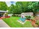 Serene backyard featuring lush greenery, decorative elements, and a charming shed with floral accents at 1491 Avenue F Ne, Winter Haven, FL 33881