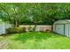 Well-maintained backyard with green grass and mature trees, creating a peaceful outdoor space at 1491 Avenue F Ne, Winter Haven, FL 33881