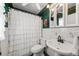 Traditional bathroom featuring a white tiled sink, toilet and shower with white curtain at 1491 Avenue F Ne, Winter Haven, FL 33881