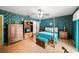 Cozy bedroom features a four-poster bed, wooden floors, and charming floral wallpaper at 1491 Avenue F Ne, Winter Haven, FL 33881