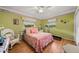 Bright bedroom with windows, with a treadmill and wicker rocking chair at 1491 Avenue F Ne, Winter Haven, FL 33881