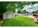 Full view of the backyard featuring a storage shed, swimming pool, and outdoor patio area at 1491 Avenue F Ne, Winter Haven, FL 33881