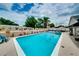 Spacious pool area with whimsical decor, lush palm trees, patio furniture, and clear blue skies above at 1491 Avenue F Ne, Winter Haven, FL 33881