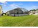 An enclosed lanai with a spacious green yard offers an ideal space for outdoor living and entertaining at 151 Hideaway Beach Ln, Kissimmee, FL 34746