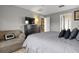 Neutral bedroom featuring a queen-size bed, a dresser with television, and an armchair at 151 Hideaway Beach Ln, Kissimmee, FL 34746