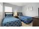 Bedroom featuring two twin beds with blue and white patterned bedding and a shared nightstand at 151 Hideaway Beach Ln, Kissimmee, FL 34746
