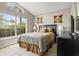 Bright bedroom featuring a queen-size bed, a large window, and earth tone colors at 151 Hideaway Beach Ln, Kissimmee, FL 34746