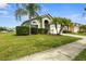 A beautifully landscaped one-story home offers a manicured lawn, shrubbery, and a two-car garage at 151 Hideaway Beach Ln, Kissimmee, FL 34746