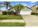 A charming one-story house is enhanced by a well-maintained lawn, professional landscaping, and two-car garage at 151 Hideaway Beach Ln, Kissimmee, FL 34746