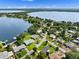 Aerial view of lakeside neighborhood with homes, green lawns, mature trees, and access to beautiful Lake Howard at 1540 N Lake Mirror Nw Dr, Winter Haven, FL 33881