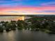 Stunning aerial view of lakeside homes at sunset with colorful sky reflecting on the calm water at 1540 N Lake Mirror Nw Dr, Winter Haven, FL 33881