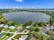Aerial view of lakefront property featuring a modern home with beautiful landscaping on Lake Cannon at 1540 N Lake Mirror Nw Dr, Winter Haven, FL 33881