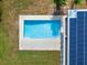 Aerial view of a private pool, patio, yard, and solar panels at 1540 N Lake Mirror Nw Dr, Winter Haven, FL 33881