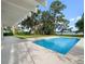 Relaxing backyard showcases a modern pool and covered patio overlooking lush greenery and waterfront views at 1540 N Lake Mirror Nw Dr, Winter Haven, FL 33881