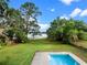 Serene backyard featuring a refreshing pool and a sprawling lawn leading to a tranquil lake view at 1540 N Lake Mirror Nw Dr, Winter Haven, FL 33881