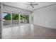 A bright bedroom with tiled floors, and sliding glass doors to a balcony allowing a beautiful view of mature trees at 1540 N Lake Mirror Nw Dr, Winter Haven, FL 33881