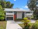 Modern two-story home featuring unique architecture, a metal roof, and mature landscaping at 1540 N Lake Mirror Nw Dr, Winter Haven, FL 33881