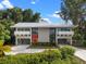Stunning home with an eye-catching red door, and full-length windows, surrounded by lush greenery at 1540 N Lake Mirror Nw Dr, Winter Haven, FL 33881