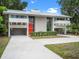 Contemporary home with ample driveway space, an overhang, and vibrant, manicured landscaping at 1540 N Lake Mirror Nw Dr, Winter Haven, FL 33881