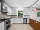 Well-lit kitchen featuring stainless steel appliances, white cabinets, and ample counter space at 1540 N Lake Mirror Nw Dr, Winter Haven, FL 33881