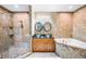 Luxurious bathroom with dual sinks, granite counters, a walk-in shower, and a soaking tub at 1553 Wright Dr, Lakeland, FL 33805