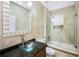 Bathroom with glass shower, tub combo, decorative stone accents, and a vessel sink at 1553 Wright Dr, Lakeland, FL 33805