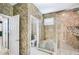 Bathroom with glass shower stall, white tile, and decorative stone accents at 1553 Wright Dr, Lakeland, FL 33805