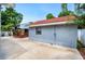 Exterior view of home with concrete pathway leading to an inviting outdoor lounge area with red roof in background at 1553 Wright Dr, Lakeland, FL 33805