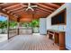 Inviting wooden patio with a fan and a TV, ideal for relaxation and entertainment amidst beautiful tropical views at 1553 Wright Dr, Lakeland, FL 33805