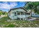 Cozy home exterior with a screened porch and lush green lawn at 165 E Pierce St, Lake Alfred, FL 33850