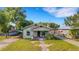 Charming bungalow with a cozy front porch, mature trees, and a convenient carport at 165 E Pierce St, Lake Alfred, FL 33850