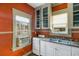 Efficient kitchen with stainless sink, white cabinets, and bright windows at 165 E Pierce St, Lake Alfred, FL 33850