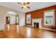 Sunlit living room features hardwood floors, a brick fireplace, and an arched doorway for seamless flow at 165 E Pierce St, Lake Alfred, FL 33850