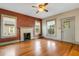 Bright living room with hardwood floors, a classic fireplace, and neutral paint, perfect for entertaining and relaxation at 165 E Pierce St, Lake Alfred, FL 33850