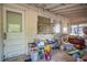 Messy sunroom with wooden ceiling, walls, door to backyard, and several windows at 165 E Pierce St, Lake Alfred, FL 33850