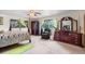 Spacious bedroom with four-poster bed, chair, and elegant wooden dresser at 1929 4Th Ne St, Winter Haven, FL 33881