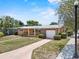 Traditional house featuring a covered porch, an attached garage, and a well-kept front yard, exuding classic suburban appeal at 1929 4Th Ne St, Winter Haven, FL 33881