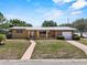 Charming single-story home featuring a brick accent wall, a covered porch, and a well-maintained front yard at 1929 4Th Ne St, Winter Haven, FL 33881