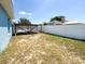 Fenced back yard features an open wood structure and solar panels on the roof of the house in the background at 2018 Misty Morning Dr, Winter Haven, FL 33880