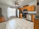 Updated kitchen with stainless steel appliances, oak cabinets, and tile floor at 2018 Misty Morning Dr, Winter Haven, FL 33880