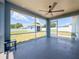 Screened-in patio with a ceiling fan, backyard view, and painted concrete floor at 2018 Misty Morning Dr, Winter Haven, FL 33880