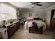Bright bedroom featuring a large window, ceiling fan, and traditional wooden dresser at 2213 W Pilaklakaha Ave, Auburndale, FL 33823