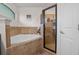 Bathroom with a large soaking tub surrounded by tile, next to glass enclosed shower at 2240 Country Manor St, Bartow, FL 33830