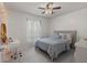 Simple bedroom with a soft grey bed, desk area, and a ceiling fan with natural light at 2240 Country Manor St, Bartow, FL 33830