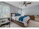 Comfortable bedroom with a ceiling fan, natural light, and modern furnishings on a white tiled floor at 2240 Country Manor St, Bartow, FL 33830