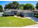 Charming single-story home with a well-manicured lawn, tidy landscaping, and a two-car garage at 2240 Country Manor St, Bartow, FL 33830