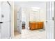 Spacious bathroom with tiled floors, a wood vanity, a shower with glass doors, and view to bedroom at 263 Reserve Dr, Davenport, FL 33896